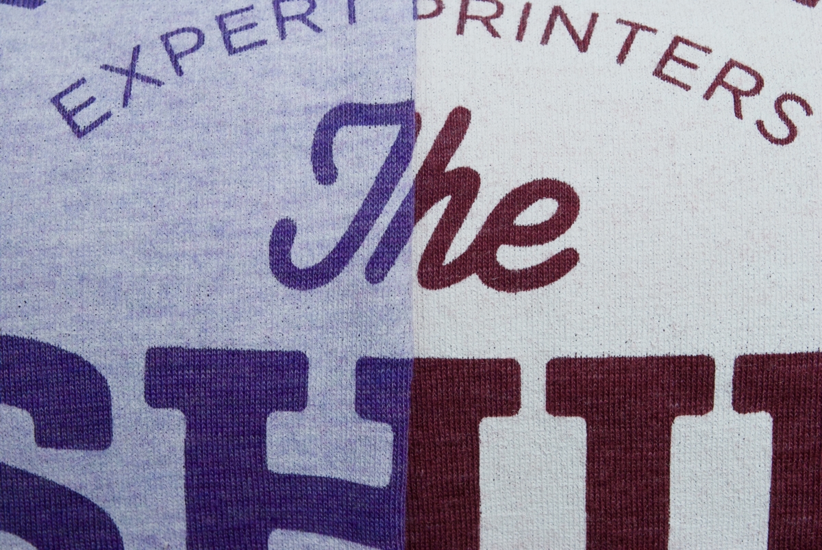 Close up of two different coloured tri-blend tees with a white discharge print on front - to show different results with the same ink