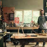 Man in workshop wearing a printed t-shirt with an abstract stool image on front.