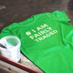 A green organic and fairtrade t-shirt on the ground with water-based ink with print on front , I am fairly traded